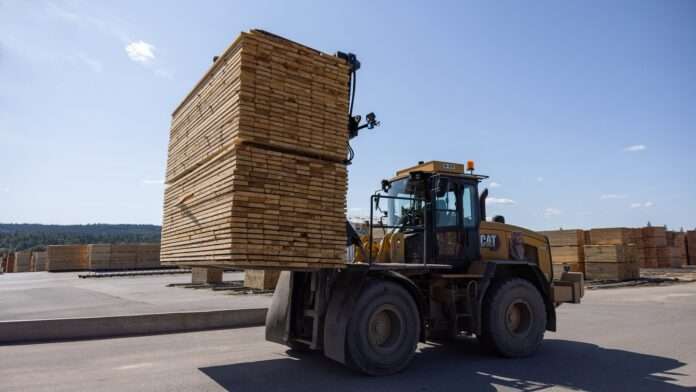 Photo of a forklift carrying pallets of lumber