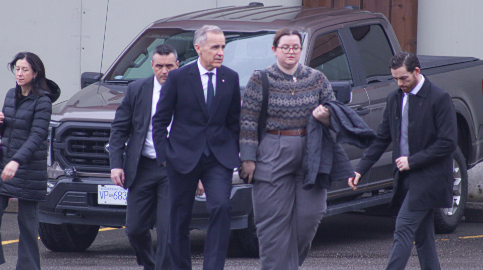 Prime Minister Mark Carney walks with staffer in Prince Rupert