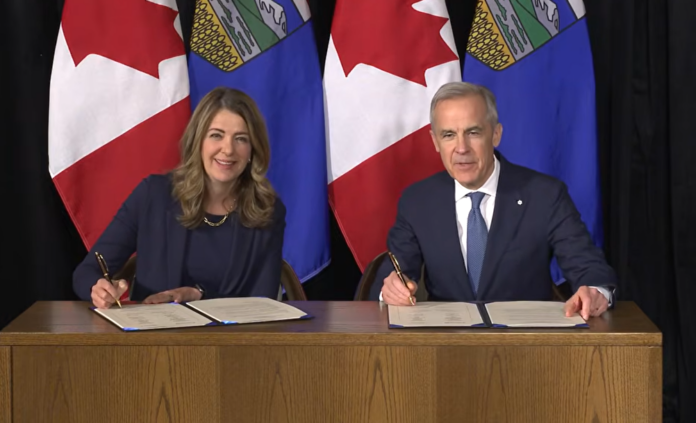 FILE photo: Alberta Premier Danielle Smith and Prime Minister Mark Carney sign implementation agreement, May 15, 2026. | Your Alberta, Youtube
