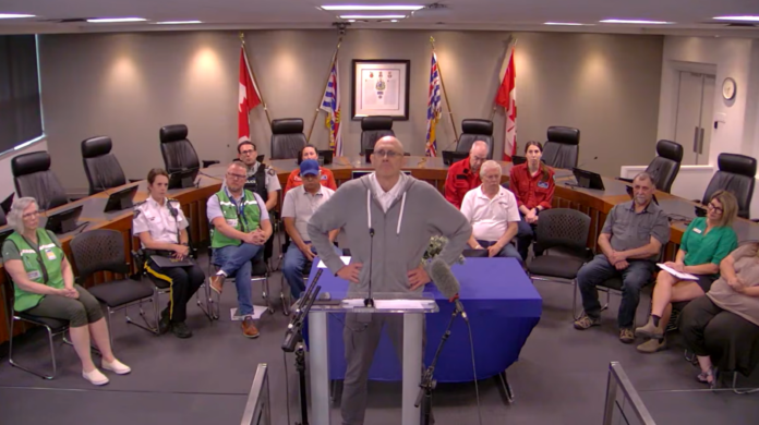 Summerland Mayor Doug Holmes pauses as he becomes emotional while speaking without notes during a Regional District of Okanagan-Similkameen wildfire briefing Monday, Aug. 10, 2026.
